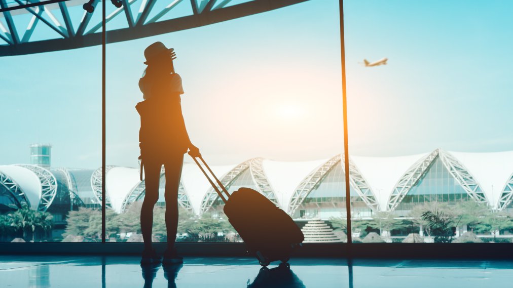 Silhouette Woman With Luggage Standing In Airport